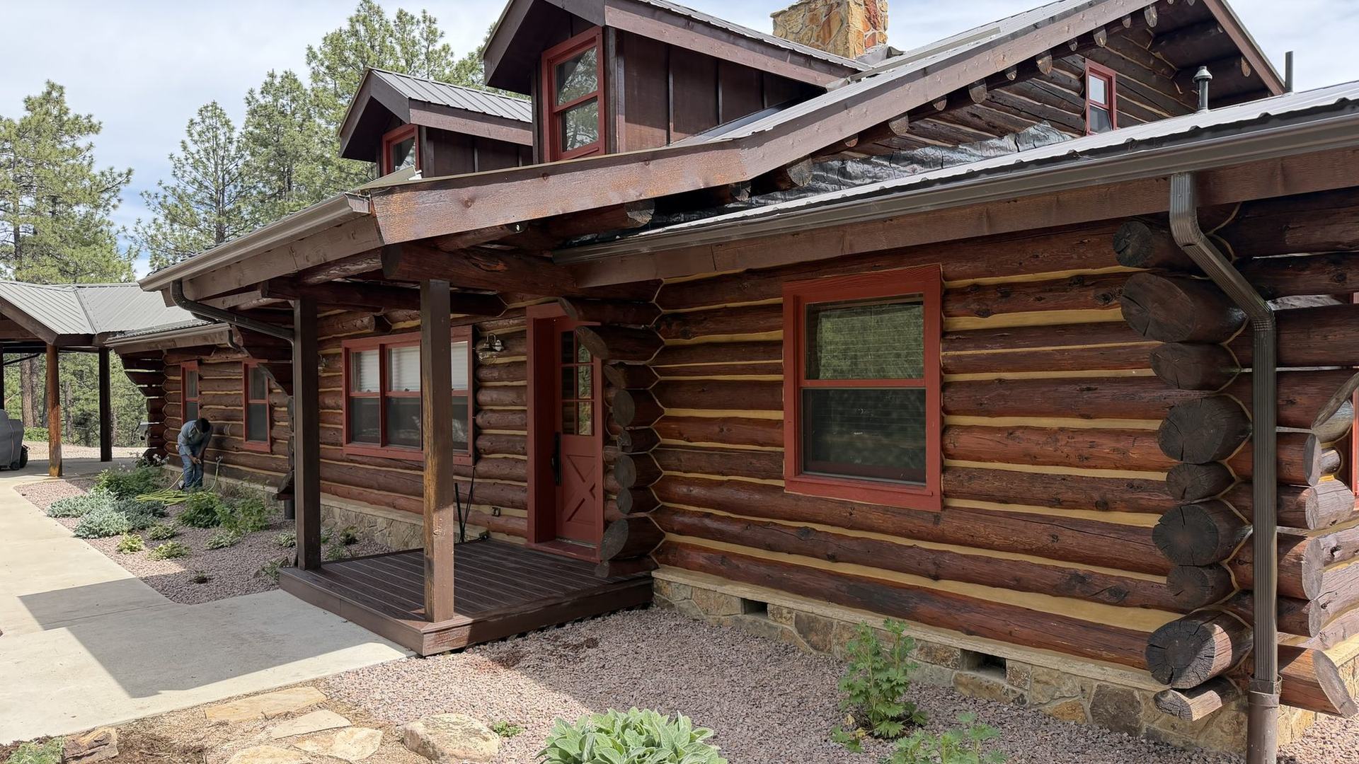 A log home in the Vallecito area with freshly stained logs, metal roofing and a covered porch, built and finished by VR Solutions
