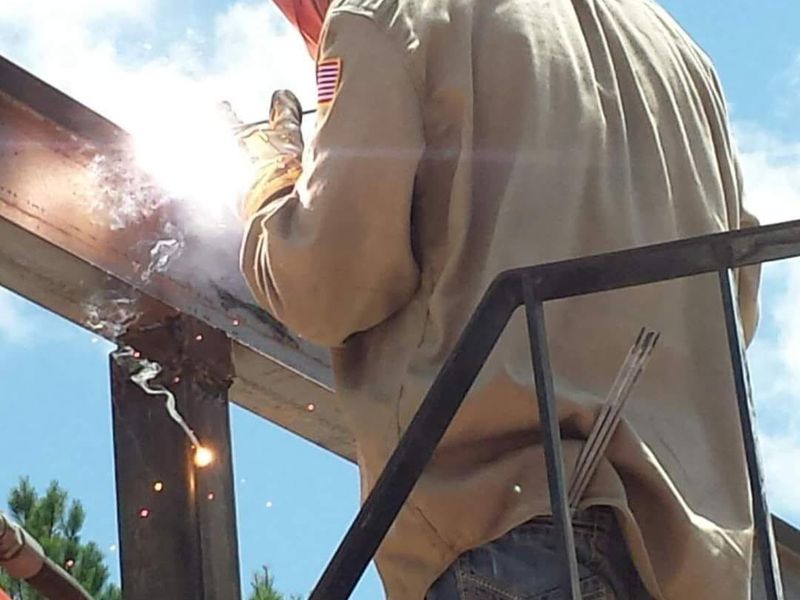 Structural steel being welded on site from a lift