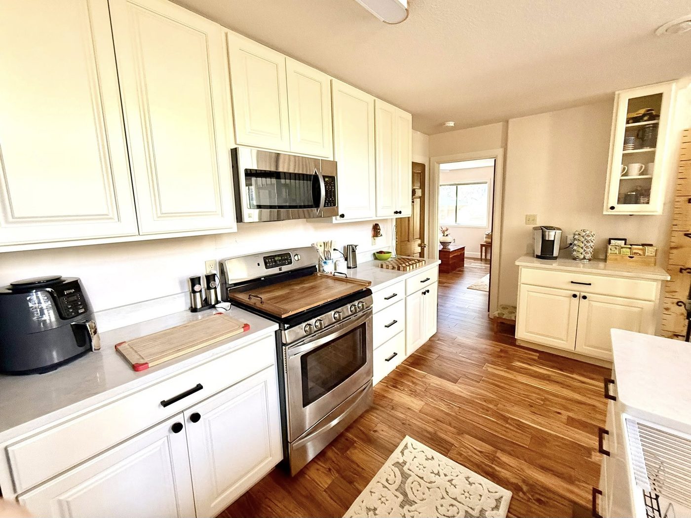 Rebuilt kitchen with white cabinets, stainless range and new hardwood floor