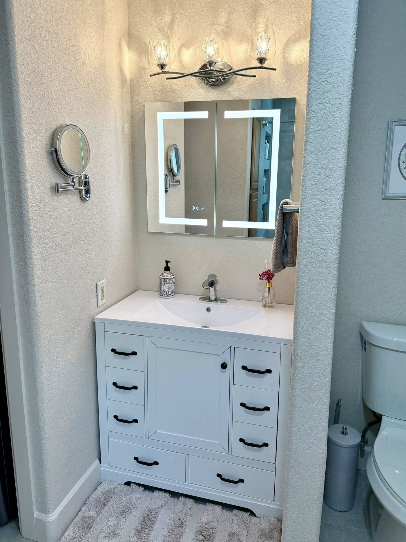 Rebuilt bathroom vanity with lighted mirror and new fixtures
