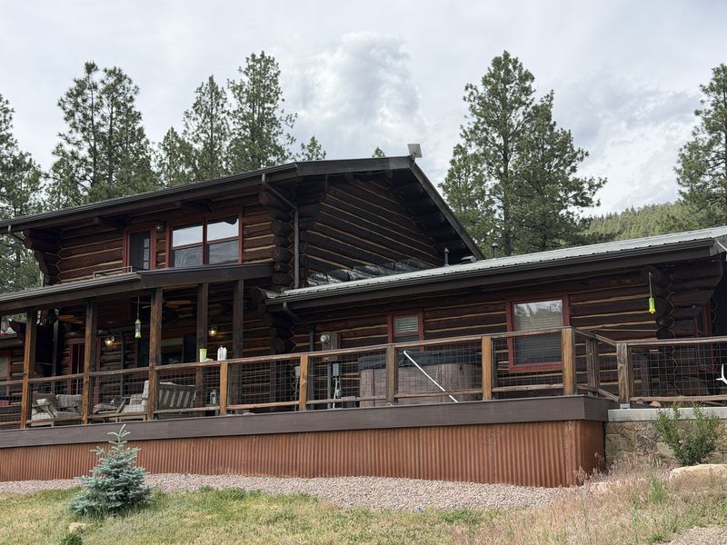 Log home with standing metal roofing and a wire-panel deck railing